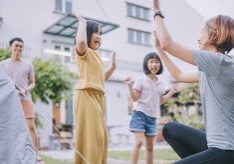 Asian chinese mother giving high-five to her daughter after setup camping tent at backyard of house